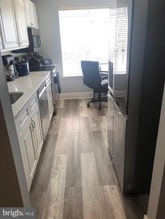 a kitchen with sink cabinets and wooden floor