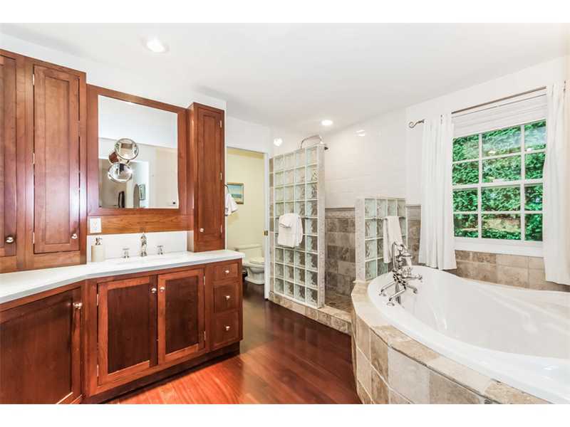 8 Milton Place Rowayton, CT 06853 - Photo 10 of 20 a bathroom with a double vanity sink a large mirror a bathtub and next to a window
