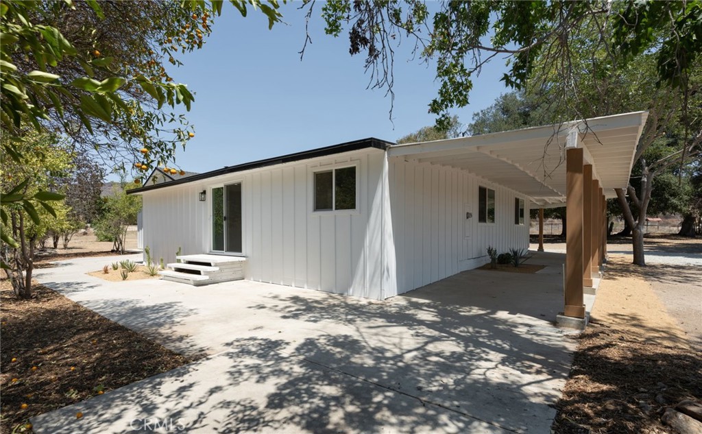37455 Quarter Valley Road Temecula, CA 92592 - Photo 15 of 64 a backyard of a house with table and chairs under an umbrella