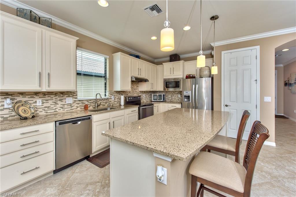 10910 Dennington Road Fort Myers, FL 33913 - Photo 3 of 25 a kitchen with granite countertop white cabinets and stainless steel appliances