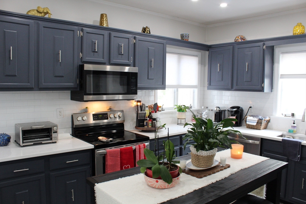 295 Haven Reading Ma, Unit 1 Reading, MA 01867 - Photo 3 of 16 a kitchen with a dining table and chairs