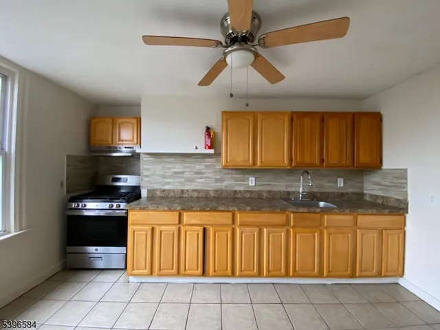 a kitchen with granite countertop a stove a sink and a microwave