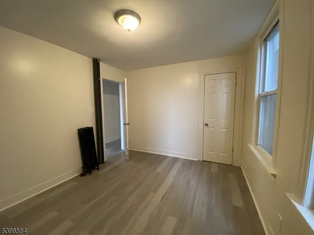 an empty room with wooden floor and a window