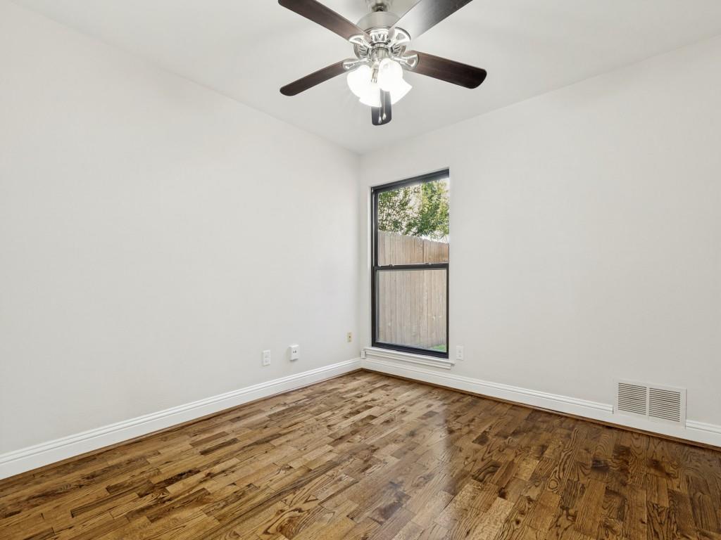 4010 Rive Lane Addison, TX 75001 - Photo 22 of 25 an empty room with wooden floor chandelier fan and windows