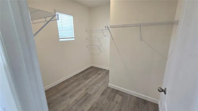 a view of a room with wooden floor and small window