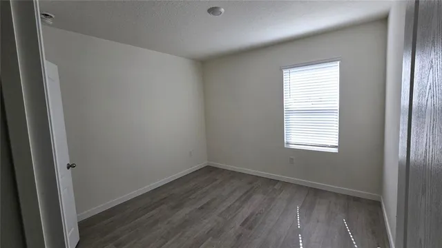a view of a room that has wooden floor and windows in it