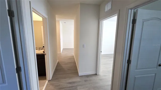 a view of a hallway with wooden floor and doors