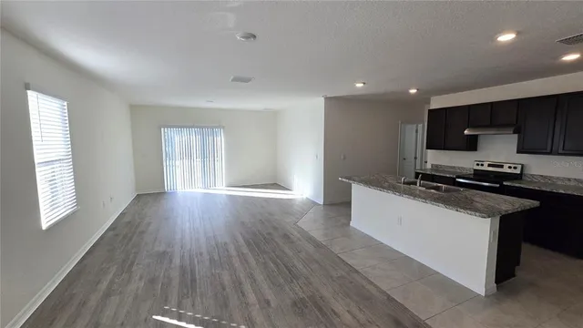 a kitchen with stainless steel appliances granite countertop a stove a sink and a refrigerator