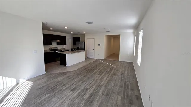 a view of a kitchen with wooden floor and stainless steel appliances