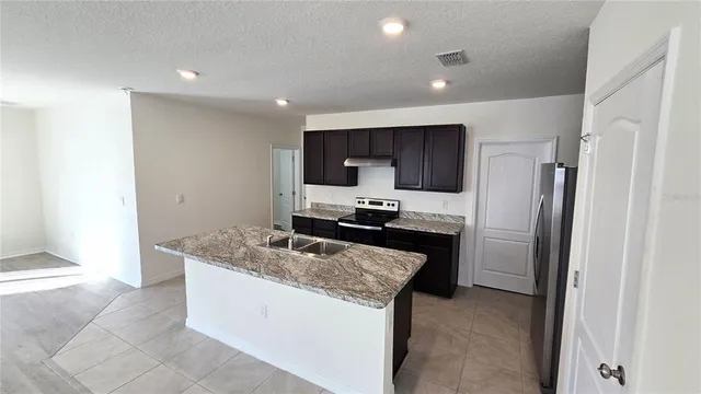 a kitchen with stainless steel appliances granite countertop a refrigerator and a sink