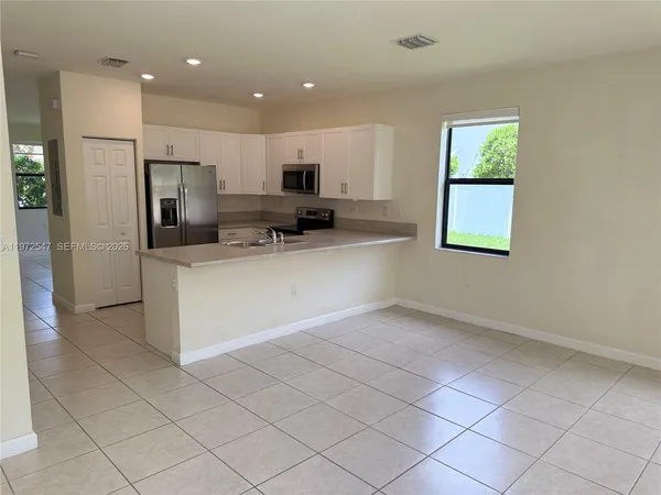 a kitchen with stainless steel appliances a refrigerator sink and microwave