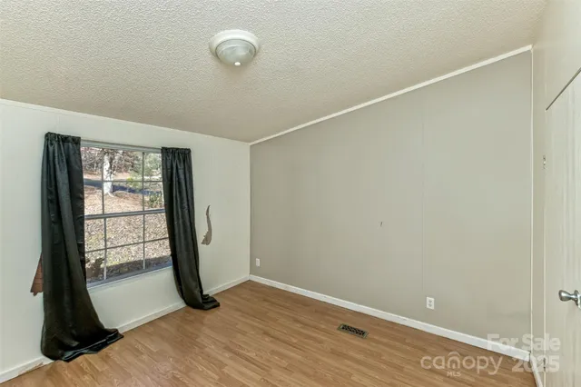 a view of a hallway with wooden floor and closet area