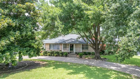 a front view of a house with yard and green space