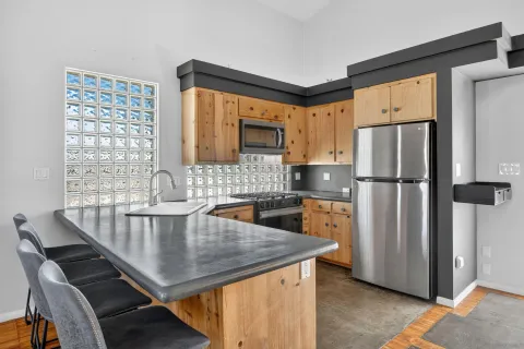 a kitchen with refrigerator and wooden cabinets