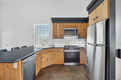 a kitchen with stainless steel appliances granite countertop a stove a refrigerator a dining table and chairs with wooden floor