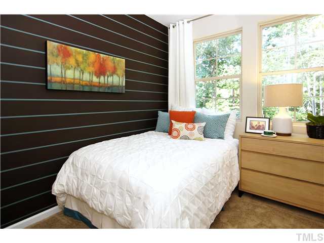 764 Wickham Ridge Road, Unit 108 Apex, NC 27539 - Photo 15 of 20 a bed sitting in a bedroom next to a window