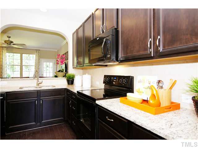 764 Wickham Ridge Road, Unit 108 Apex, NC 27539 - Photo 7 of 20 a kitchen with a sink a stove and cabinets