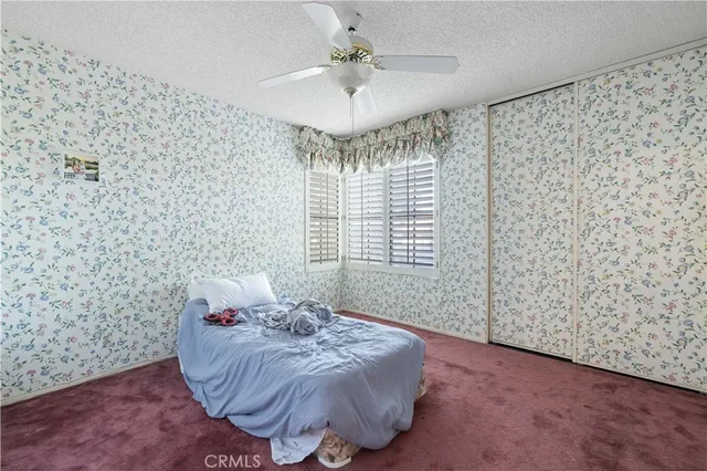 a spacious bedroom with a bed and a chandelier