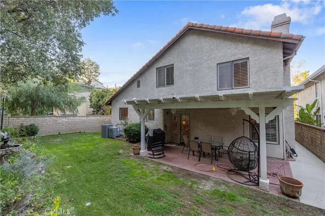 a view of a house with a yard and chairs