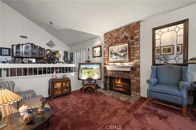 a living room with furniture a fireplace and a large window