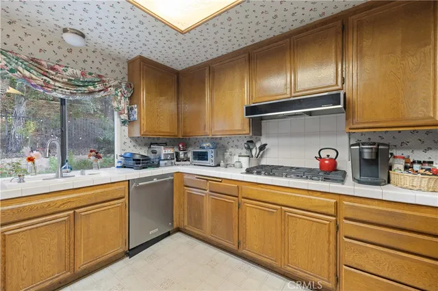 a kitchen with cabinets stainless steel appliances and a sink
