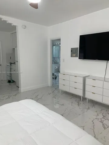 a bedroom with a bed and flat screen tv