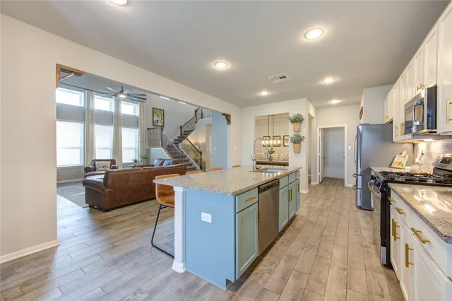 a kitchen with stainless steel appliances granite countertop a stove and a sink