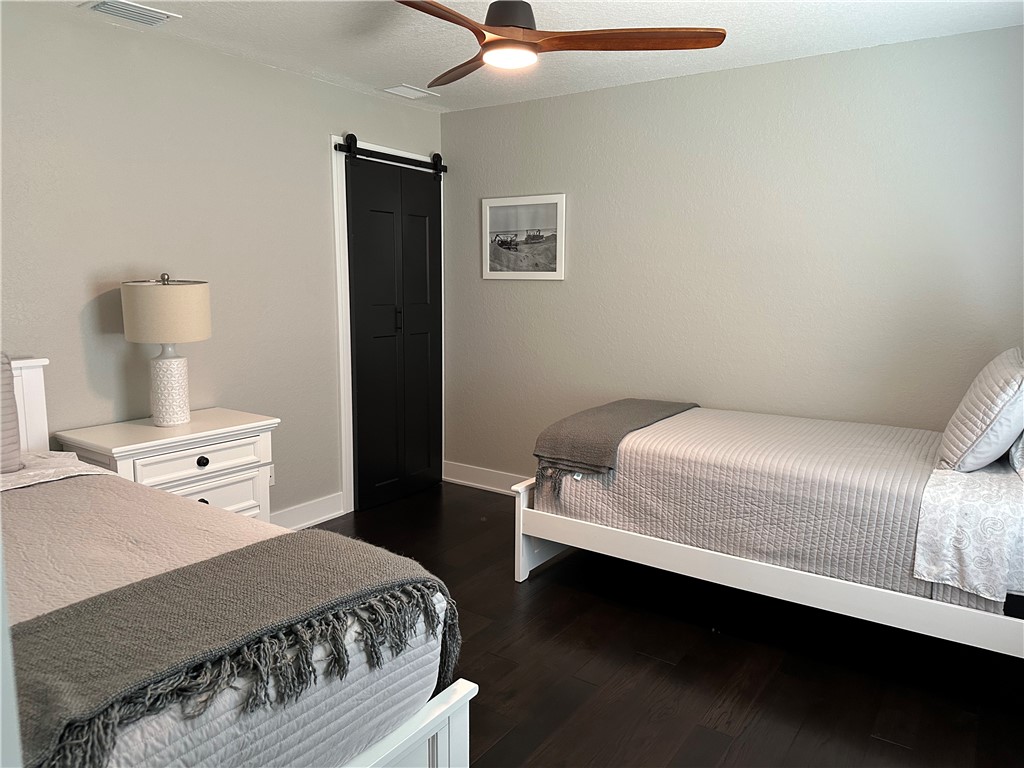 4135 Grant Road Grant Valkaria, FL 32949 - Photo 19 of 26 a bedroom with a bed and a lamp on the dresser