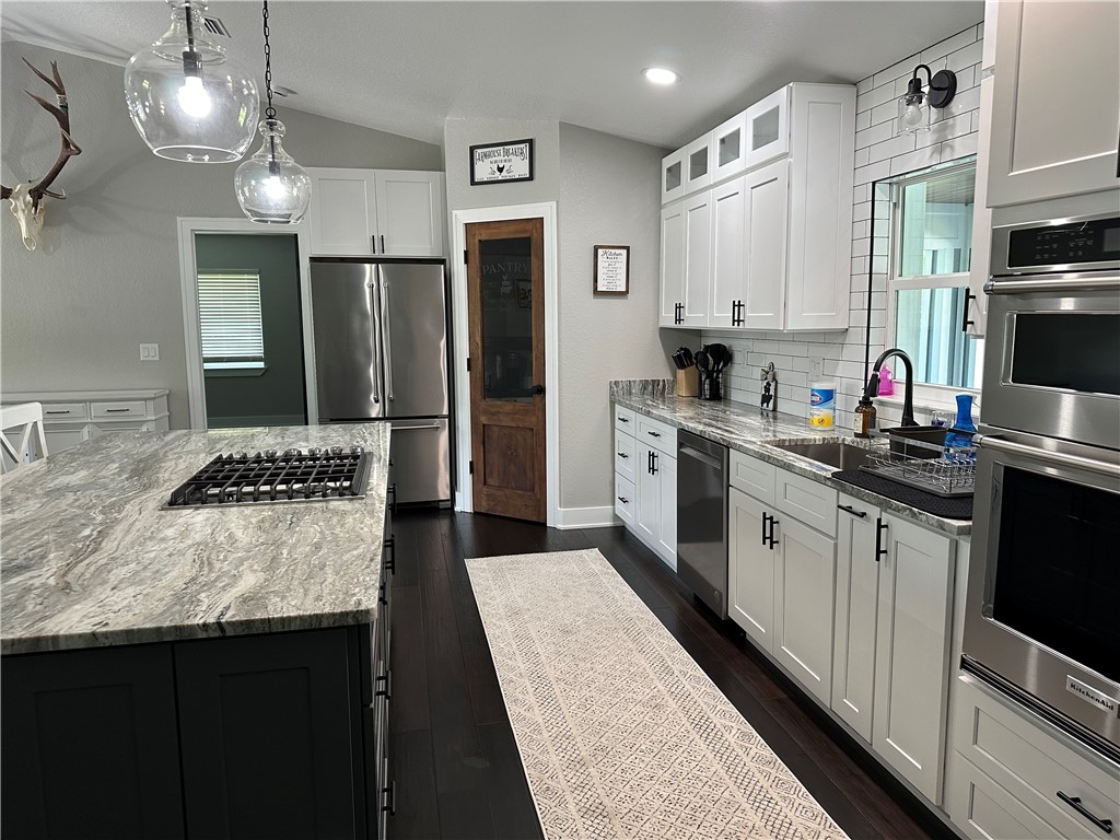 4135 Grant Road Grant Valkaria, FL 32949 - Photo 8 of 26 a kitchen with stainless steel appliances a stove refrigerator sink and microwave