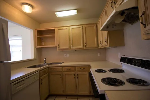 a kitchen with a sink a stove and cabinets