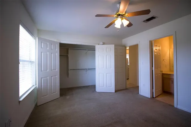 a view of empty room with ceiling fan