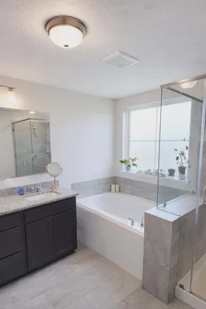 a bathroom with a tub sink and mirror