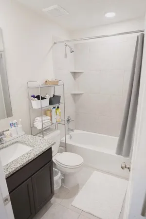 a bathroom with a granite countertop sink toilet and shower