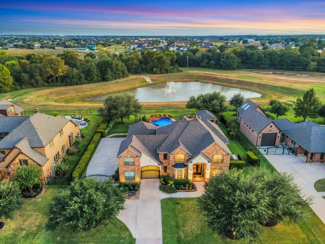 an aerial view of a house with a swimming pool and ocean view
