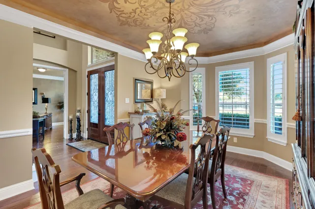 a view of a dining room with furniture and a chandelier