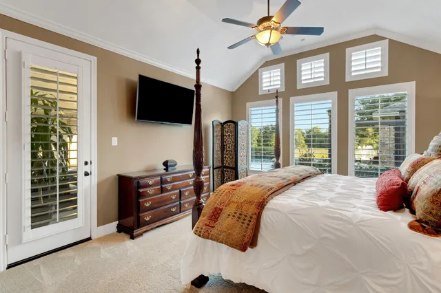 a bedroom with a bed and a flat tv screen on wall
