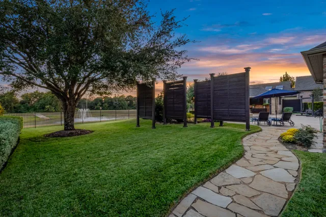 a view of a garden with a house in the background