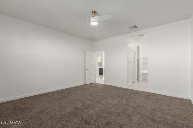 an empty room with an entryway and fan