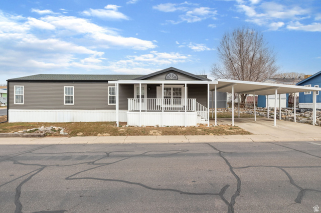 332 Hillgate Way Layton, UT 84041 - Photo 19 of 26 Manufactured / mobile home featuring covered porch, an attached carport, and concrete driveway