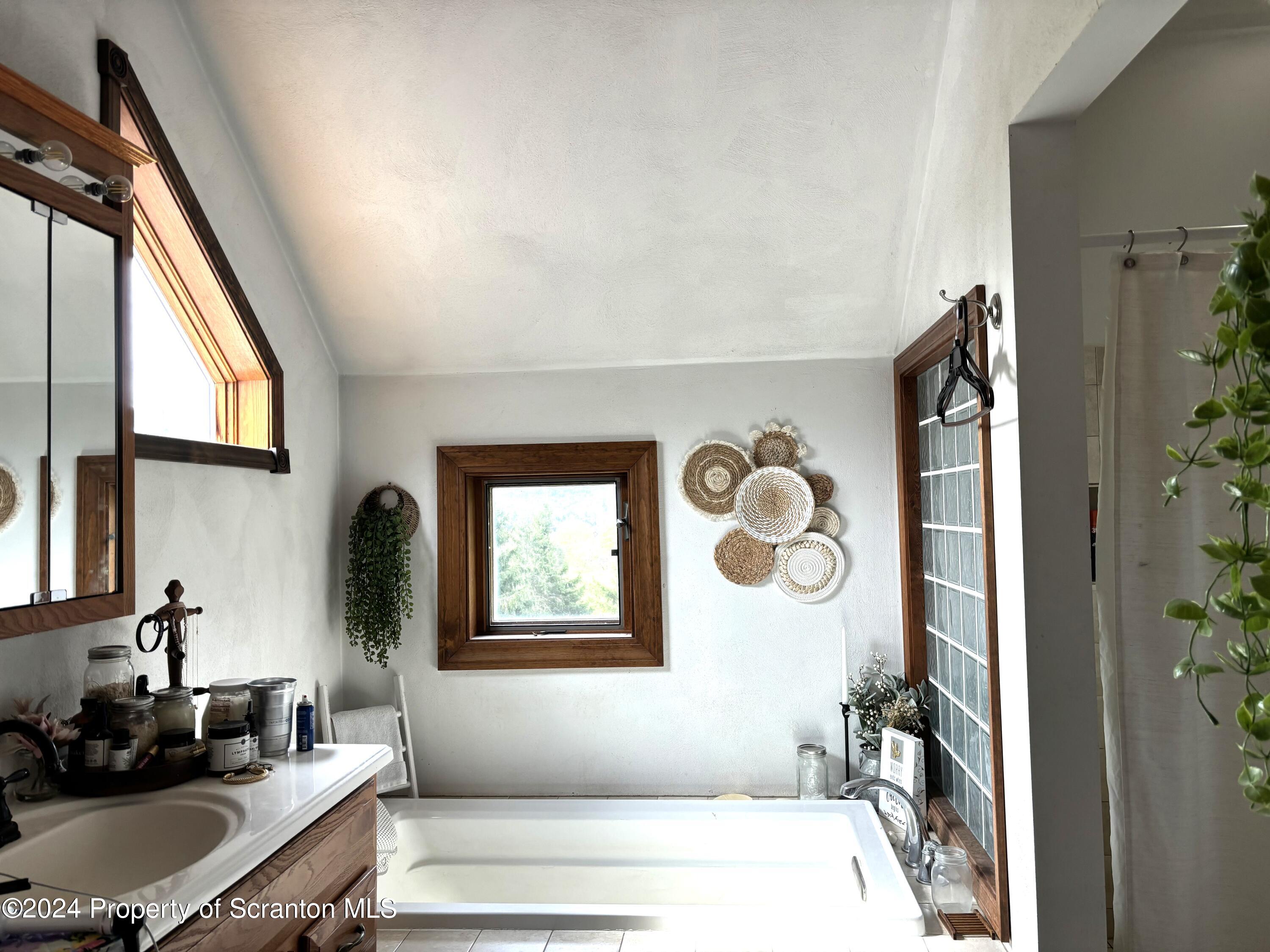2053 Silver Creek Road Montrose, PA 18801 - Photo 5 of 10 a bathroom with a tub sink and mirror