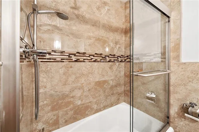 a bedroom with a bed table chair and a two windows