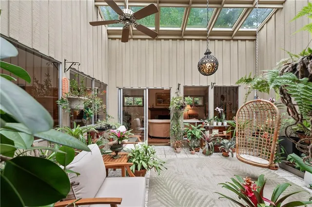 a front view of a house with outdoor seating and lots of potted plant