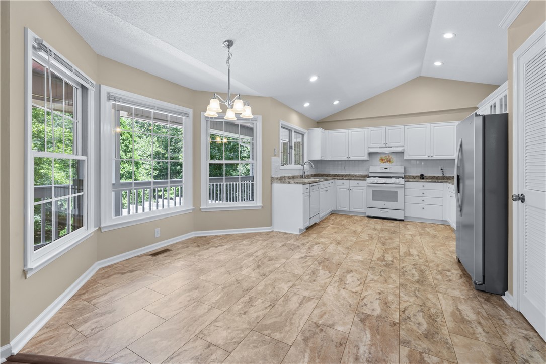 429 Burns Mill Road West Union, SC 29696 - Photo 11 of 49 A well-lit kitchen with soaring vaulted ceilings features ample counter space and a serene tree-filled view.