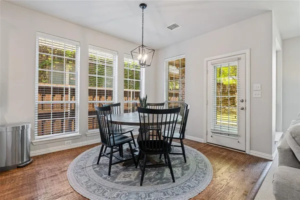 a dining room with furniture a chandelier and wooden floor