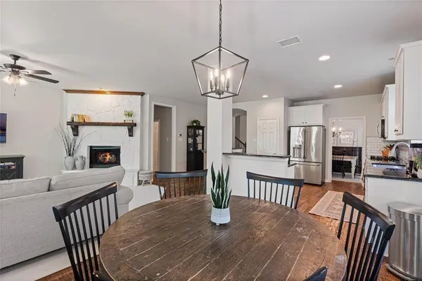 a dining room with furniture a chandelier and wooden floor