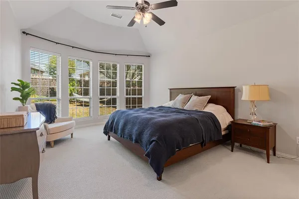 a spacious bedroom with a bed and glass window