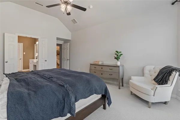 a spacious bedroom with a bed and ceiling fan