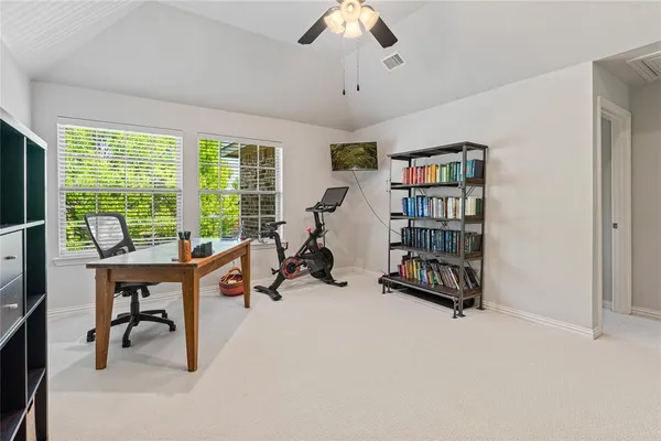 a view of a workspace with furniture and a window