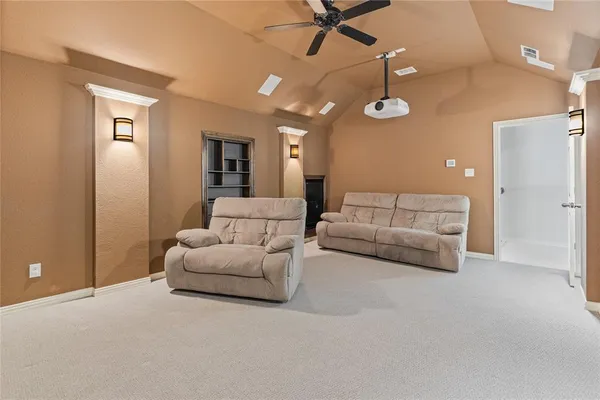 a living room with furniture and a ceiling fan