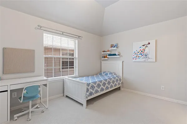 a bedroom with a bed and a desk in it